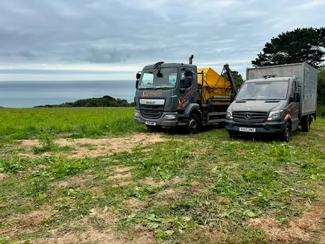 Dartmouth Midi Skips skip lorry and caged van on a job near the coast South Hams
