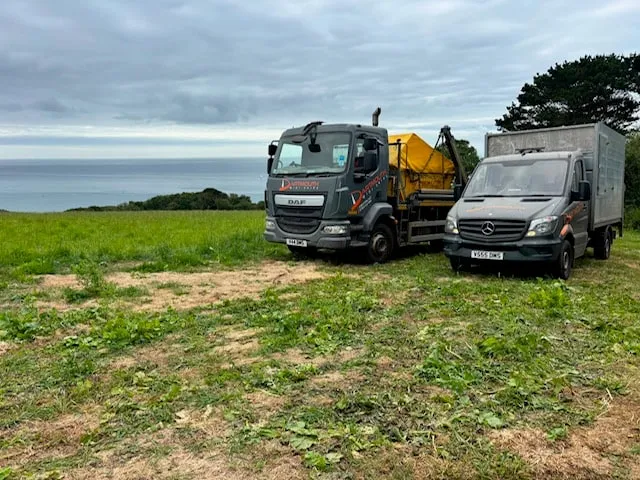 Dartmouth Midi Skips DAF skip lorry and Mercedes caged van parked on a clifftop job in the South Hams