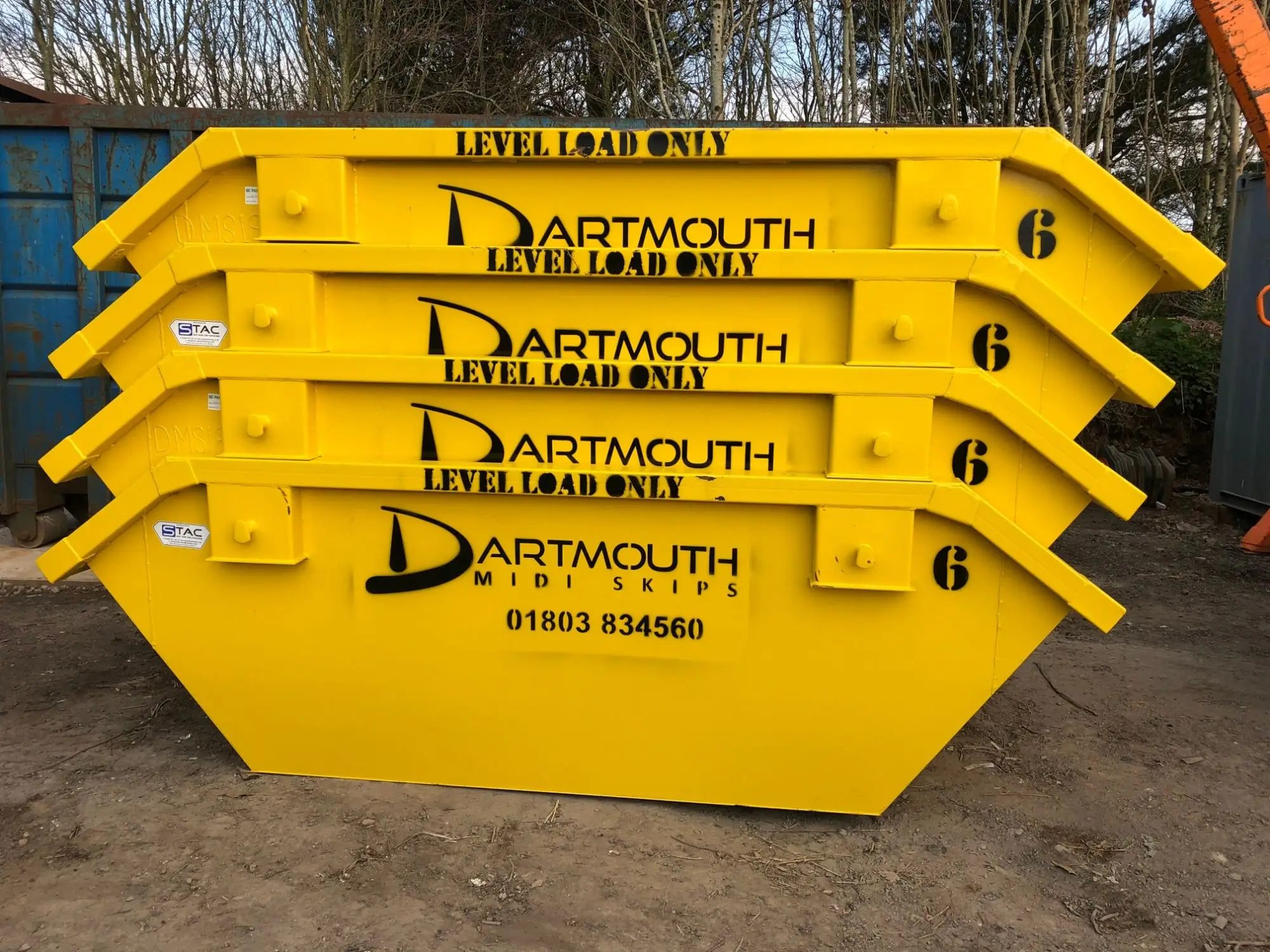 Yellow 6 yard skips stacked at the Dartmouth Midi Skips yard Dartmouth