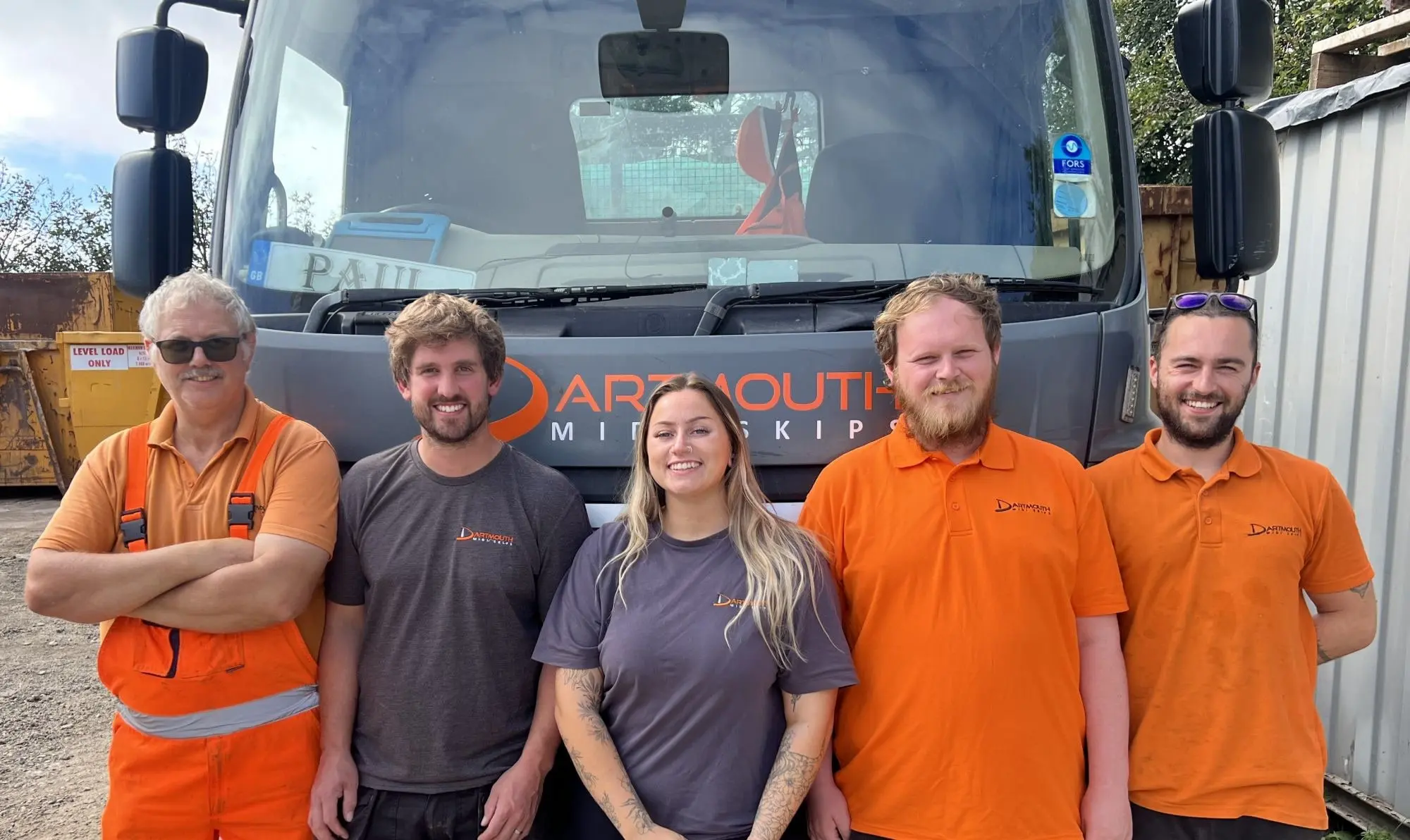 The Dartmouth Midi Skips team standing in front of a skip lorry at the Dartmouth yard